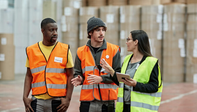 Two male employees stand next to a female employee representing the gender gap in manufacturing.