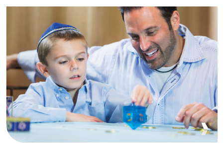 Little boy and father playing dreidel