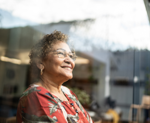 Elderly woman looking out the window smiling